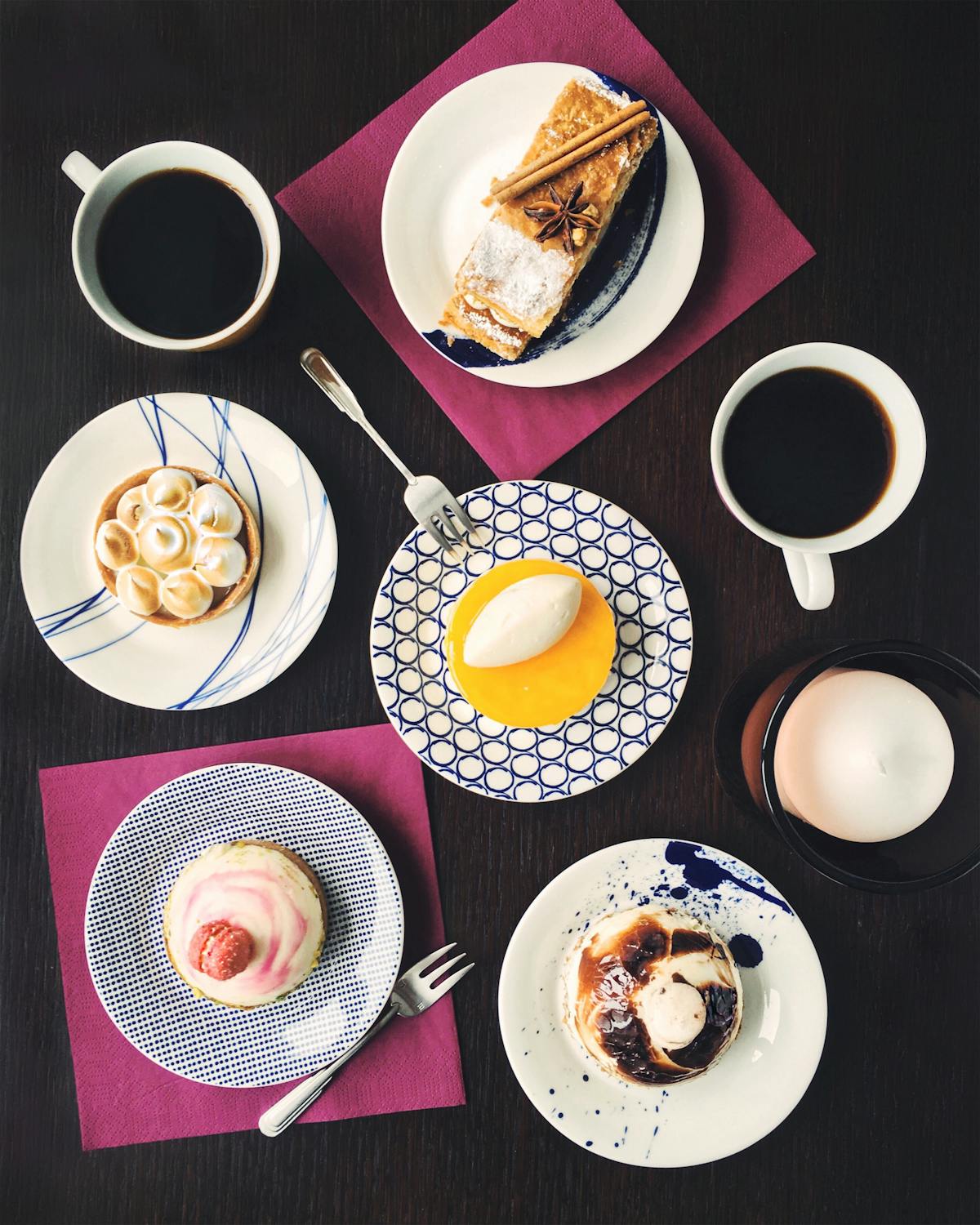Des desserts dans des assiettes sur une table noire.